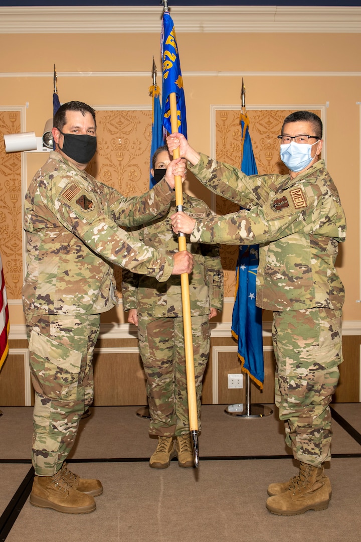 Col. Christopher G. Batterton, 192nd Wing commander, left, passes the 192nd Medical Group guidon to Col. Frank Y. Yang marking his assumption of command for the group.