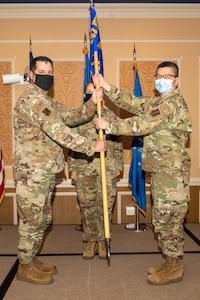 Col. Christopher G. Batterton, 192nd Wing commander, left, passes the 192nd Medical Group guidon to Col. Frank Y. Yang marking his assumption of command for the group.