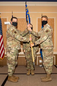 Col. Jason R. Price, outgoing 192nd Medical Group commander, right, hands off the guidon to Col. Christopher G. Batterton, 192nd Wing commander, as he relinquishes command of the group.
