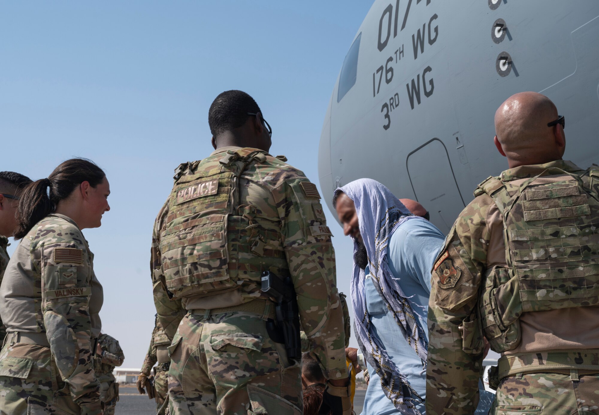 Afghanistan evacuees arrive on a C-17 Globemaster III aircraft, crewed by Alaska Air National Guard members from the 144th Airlift Squadron, of the 176th Wing, and active-duty Airmen from the 517th Airlift Squadron, of the 3rd Wing, at Ali Al Salem Air Base, Kuwait, Aug. 23, 2021. U.S. Air Force Airmen are assisting with evacuations of Americans and allied civilian personnel from Afghanistan.
