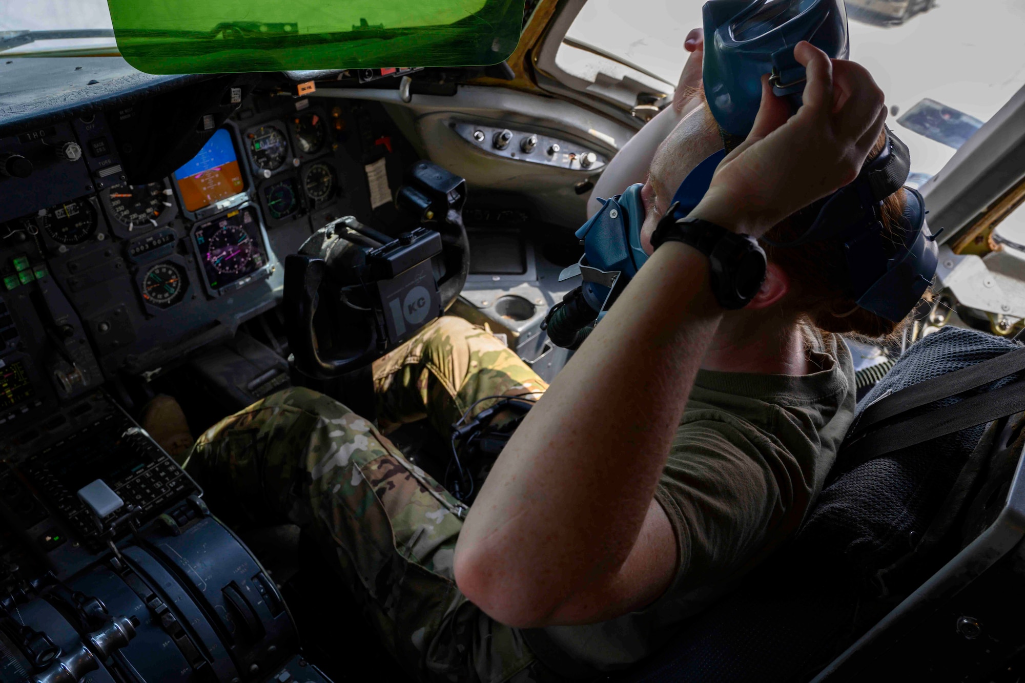 Female co-pilot in aircraft putting on oxygen mask