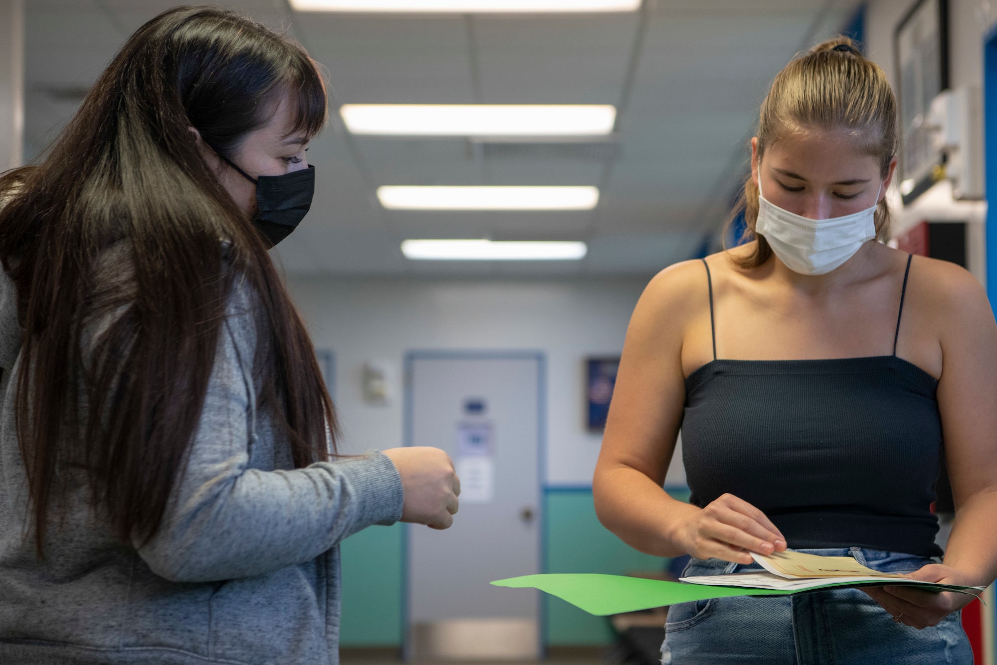 Karina Galang, Public Health Activity Japan, Okinawa Branch, animal health assistant, goes over medical information with, Katie Lambie, dependent, on Kadena Air Base, Japan, Aug. 25, 2021. The vet clinic supports wellness exams, sick call appointments, general surgery, and specialty surgery procedures. (U.S. Air Force photo by Staff Sgt. Rhett Isbell)