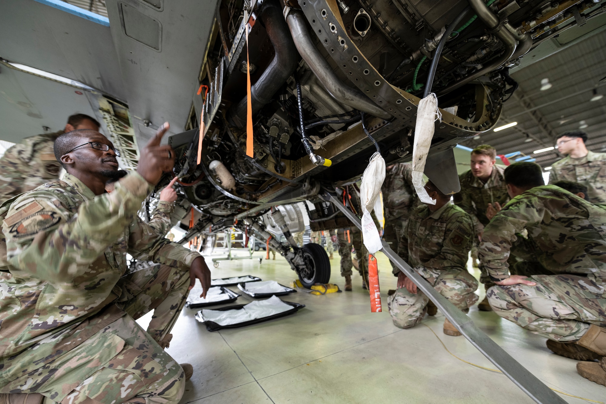 U.S. Air Force noncommissioned officers participating in the Atlantic Stripe Conference listen to briefings about U.S. Air Force F-16 Fighting Falcon fighter jet components during the conference on Spangdahlem Air Base, Germany, Aug. 19, 2021.