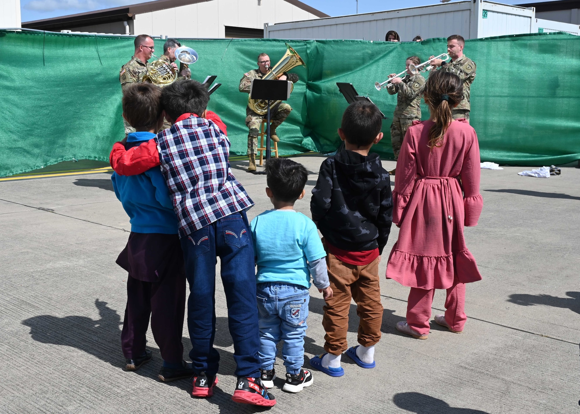 Children evacuees listens to Army band music.