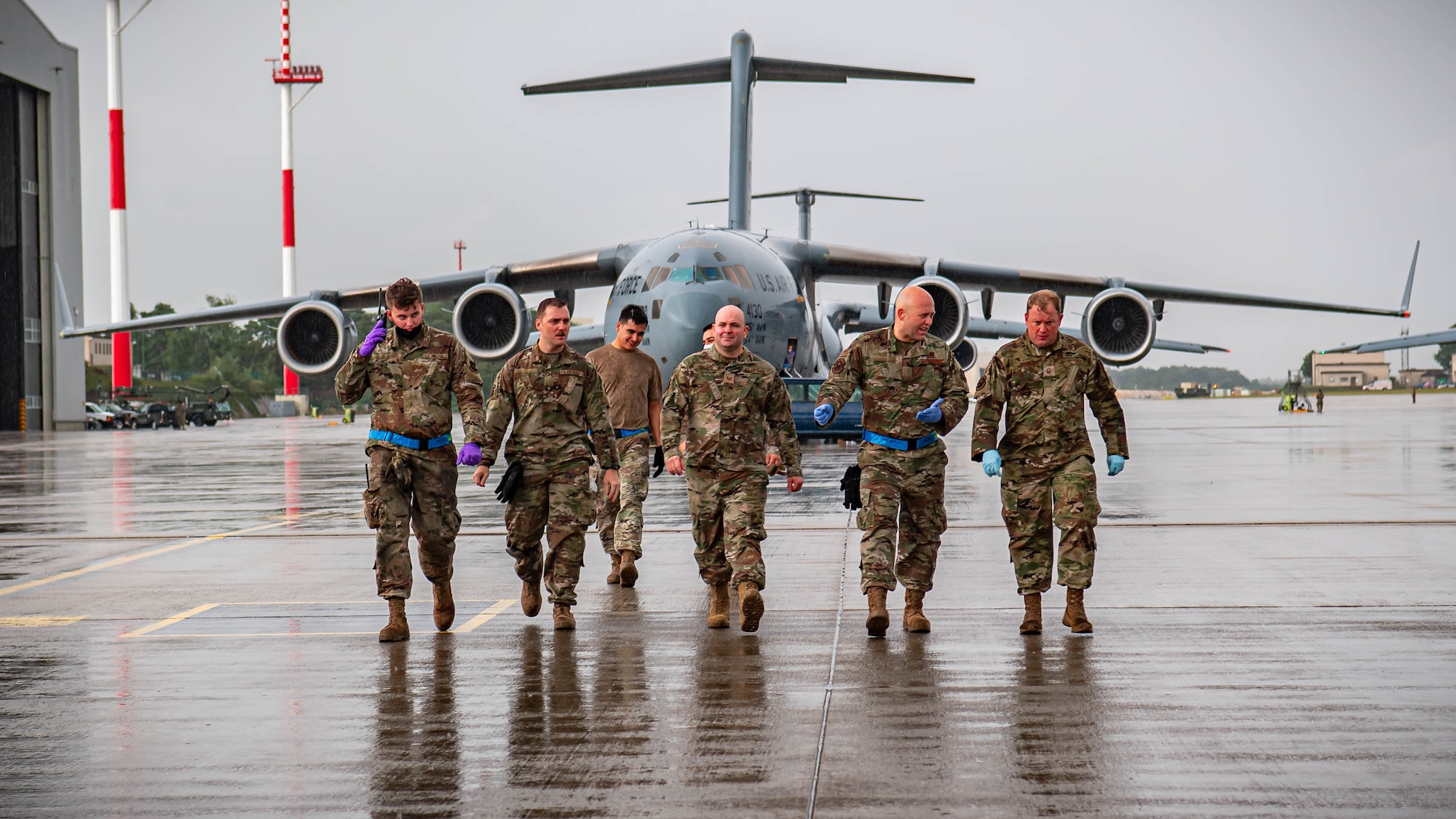 Airmen walk on flightline.