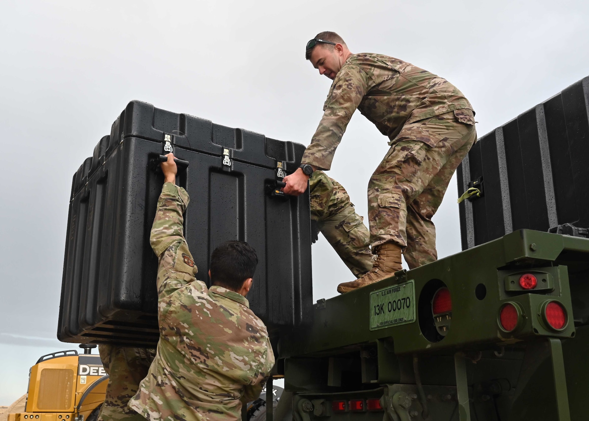 Airmen load supplies on truck.