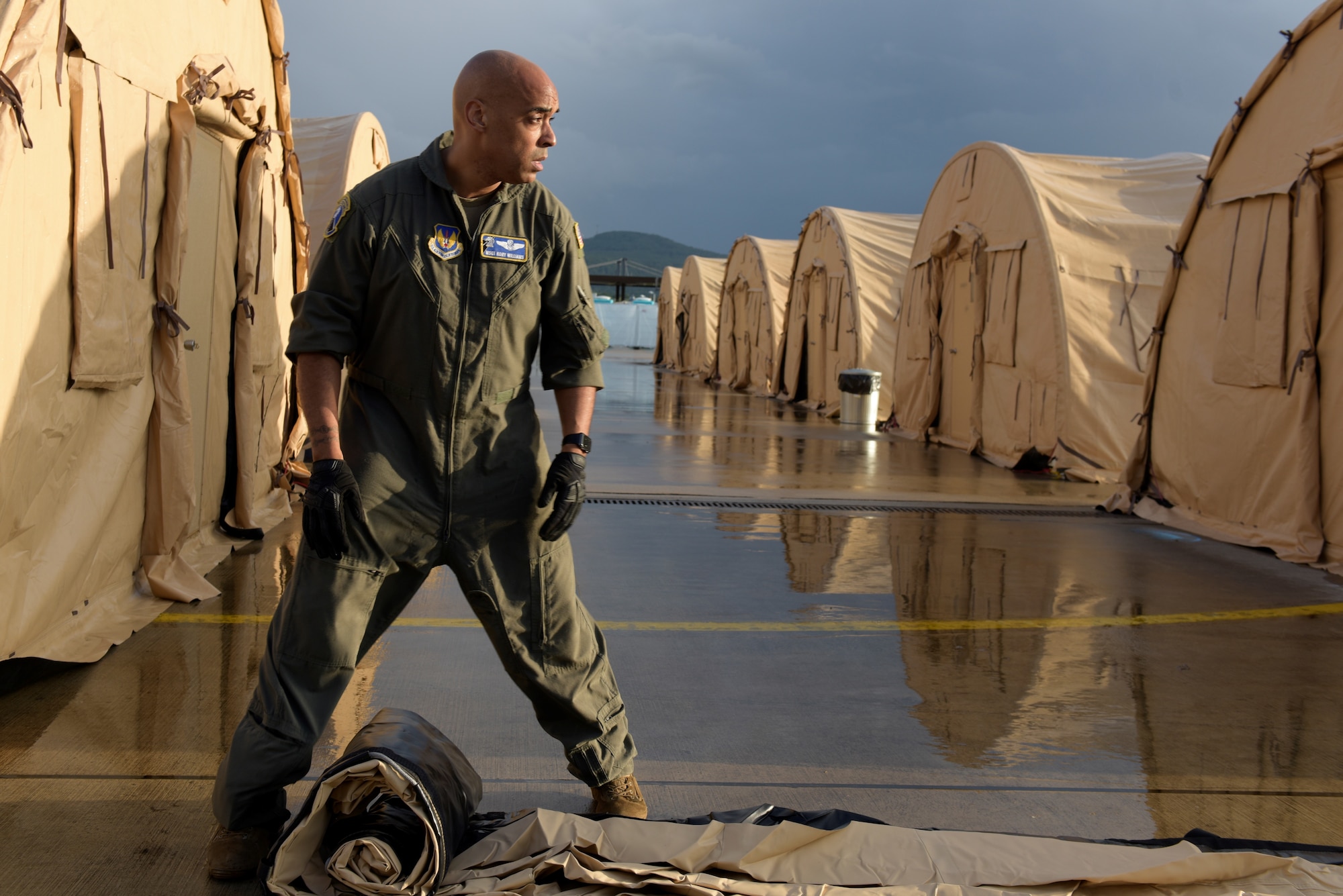 Airman unrolls pod cover.