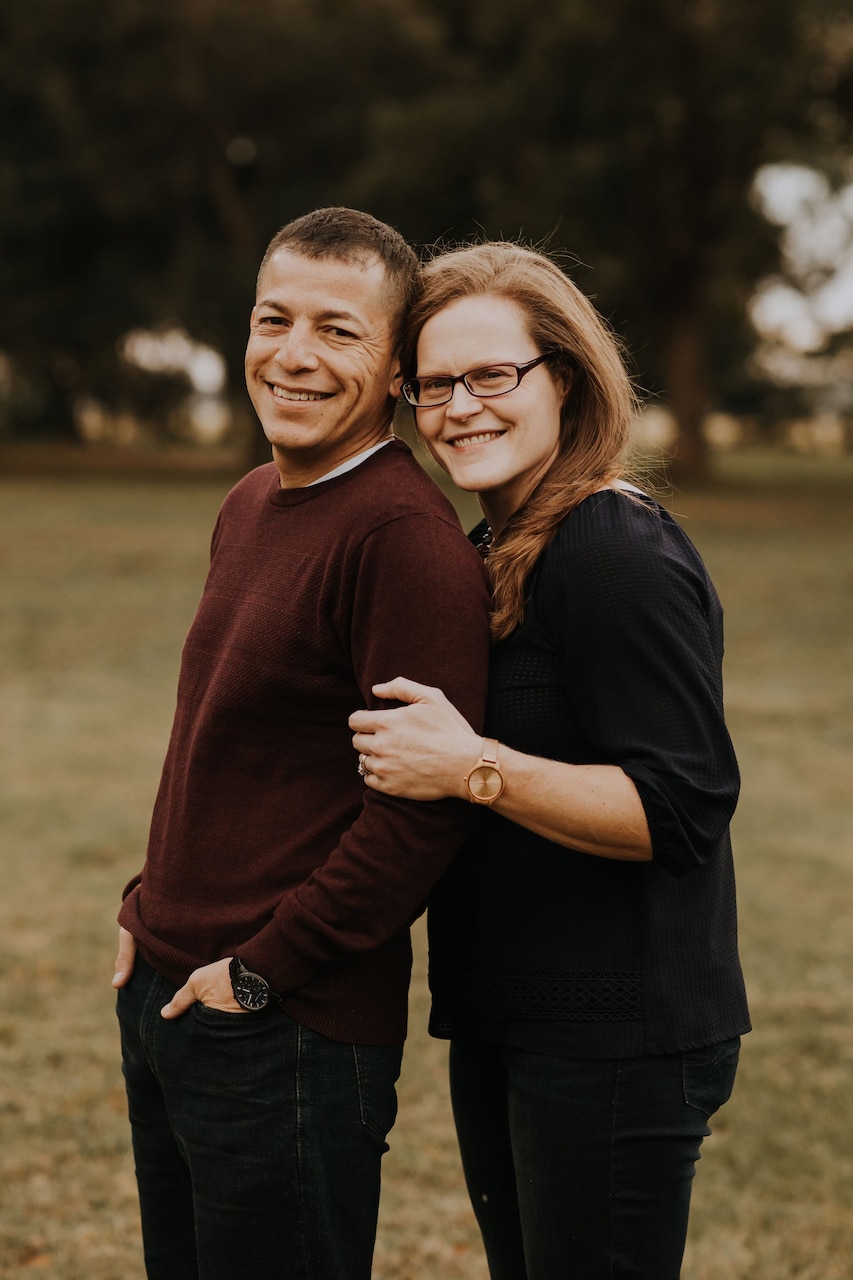 A husband and a wife pose for a photo.