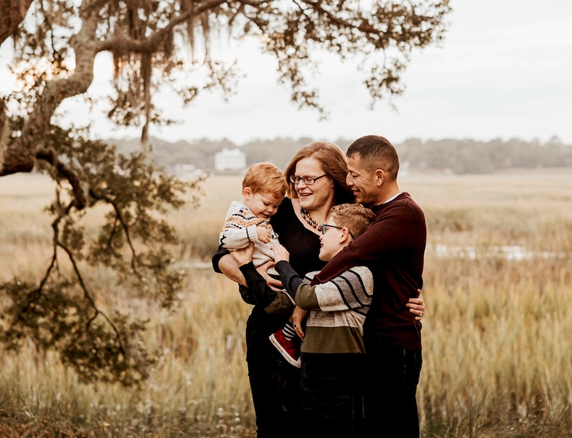 A family poses for a photo in a grassy field.