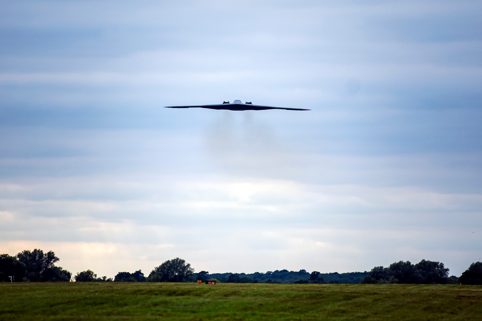 A B-2 Spirit assigned to the 509th Bomb Wing flies overhead at RAF Fairford, England, Aug. 25, 2021. The B-2 flyover was part of a Bomber Task Force mission in which aircraft conduct theater and flight training across Europe and Africa. These bomber missions enhance readiness and provide the training necessary to respond to any potential crisis or challenge across the globe. (U.S. Air Force photo by Senior Airman Eugene Oliver)