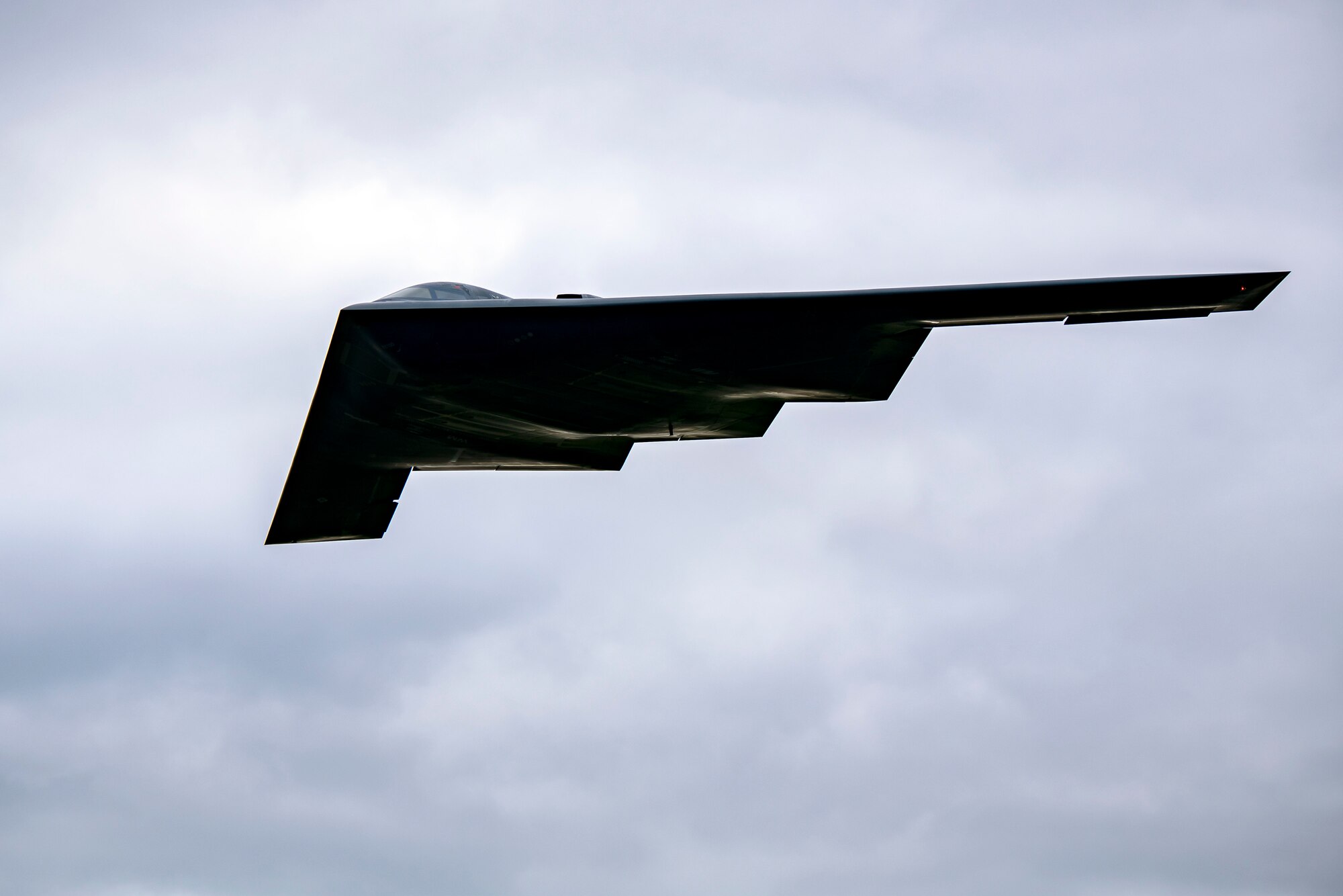 A B-2 Spirit assigned to the 509th Bomb Wing flies overhead at RAF Fairford, England, Aug. 25, 2021. The B-2 flyover was part of a Bomber Task Force mission in which aircraft conduct theater and flight training across Europe and Africa. The BTF missions, which have been occurring since 2018, provide theater familiarization for aircrew members and opportunities for U.S. integration with NATO allies and regional partners. The bomber missions enhance readiness and provide the training necessary to respond to any potential crisis or challenge across the globe. (U.S. Air Force photo by Senior Airman Eugene Oliver)