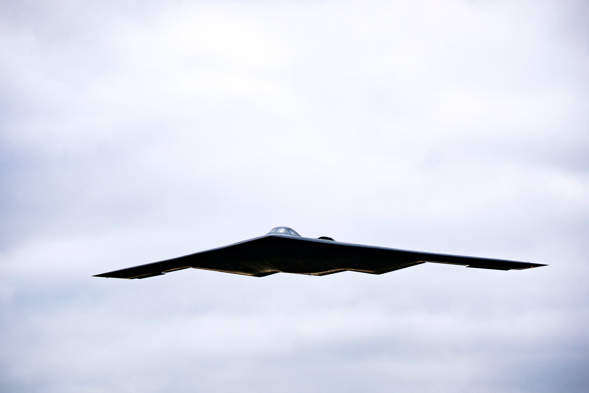 A B-2 Spirit assigned to the 509th Bomb Wing flies overhead at RAF Fairford, England, Aug. 25, 2021. The B-2 flyover was part of a Bomber Task Force mission in which aircraft conduct theater and flight training across Europe and Africa. These bomber missions enhance readiness and provide the training necessary to respond to any potential crisis or challenge across the globe. (U.S. Air Force photo by Senior Airman Eugene Oliver)