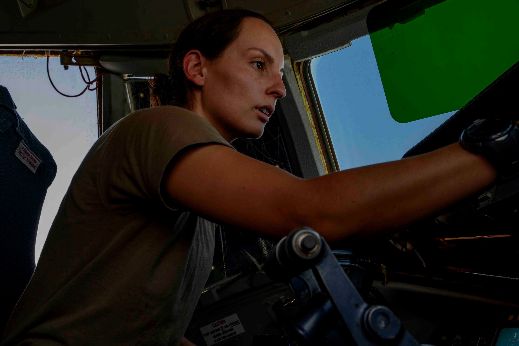 Female pilot conducts pre-flight checks in cockpit of aircraft