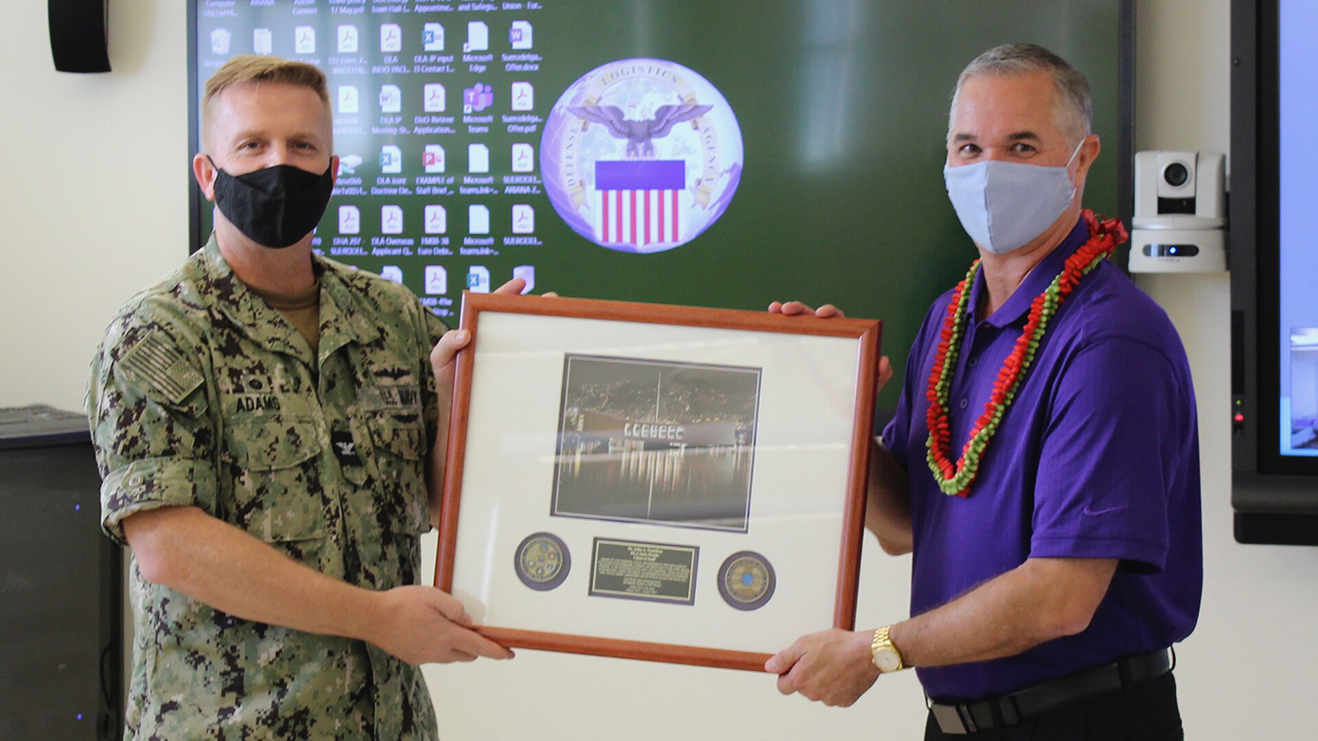 Commander presenting farewell plaque to an employee.