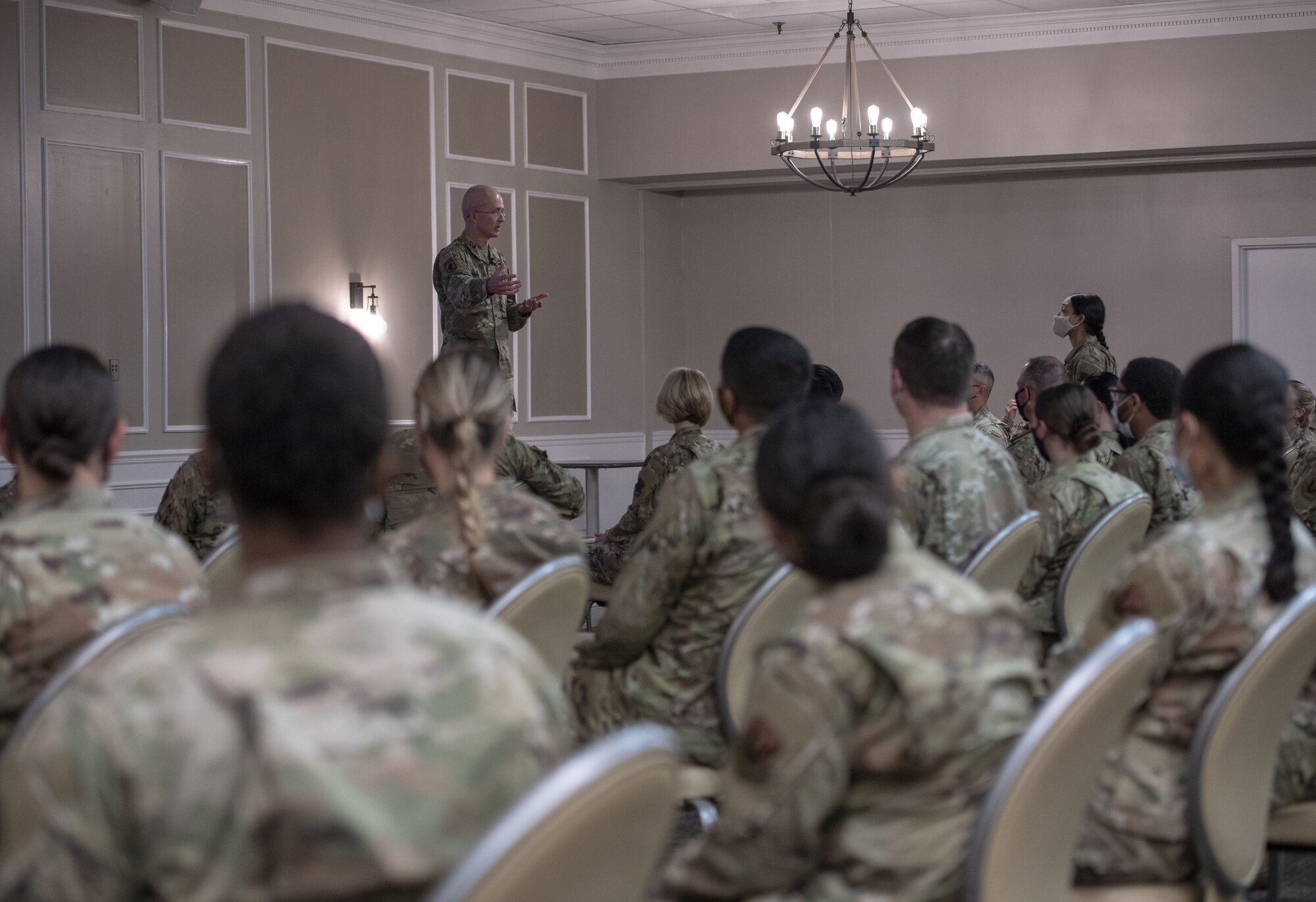 Photo of a Soldier speaking to Airmen.
