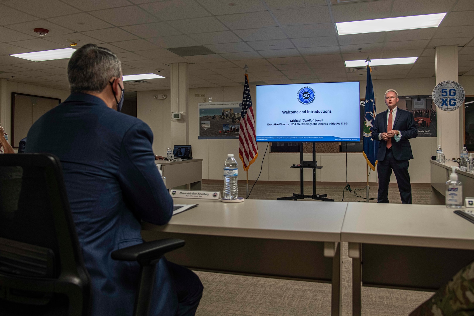 Man briefing in front of a video presentation