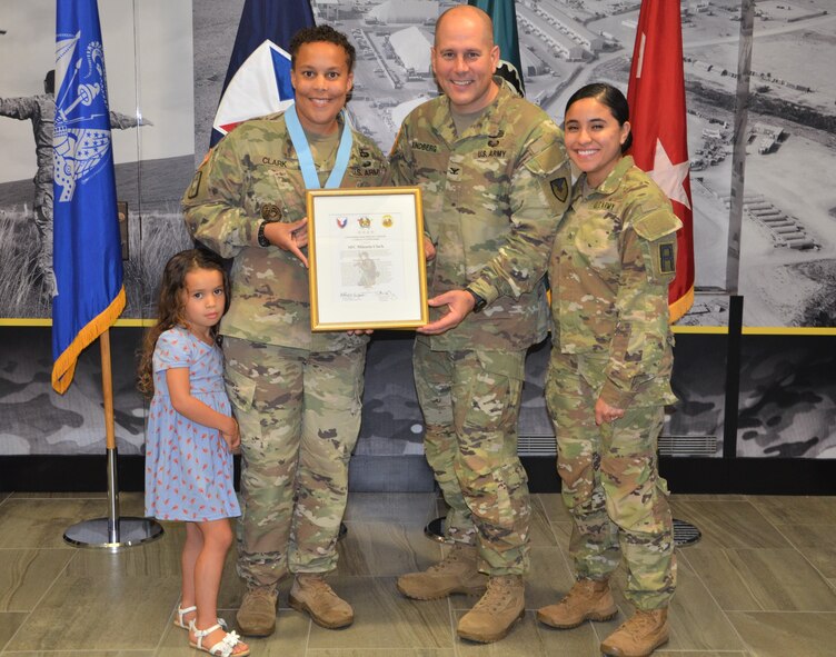 Sgt. 1st Class Mikaela Clark, provost sergeant, U.S. Army Sustainment Command, gathers for a photo with Kameron, her daughter, Col. Scott Kindberg, ASC chief of staff, and Sgt. Emily Cabrera, First U.S. Army, her fiancée, after being inducted into the Sergeant Audie Murphy Club at Rock Island Arsenal, Illinois, July 30.