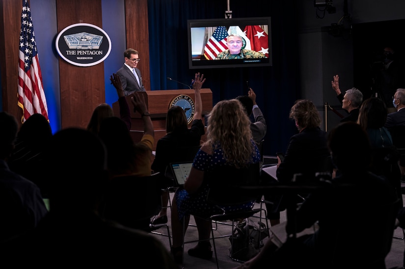 A man stands at a lectern in front of an audience