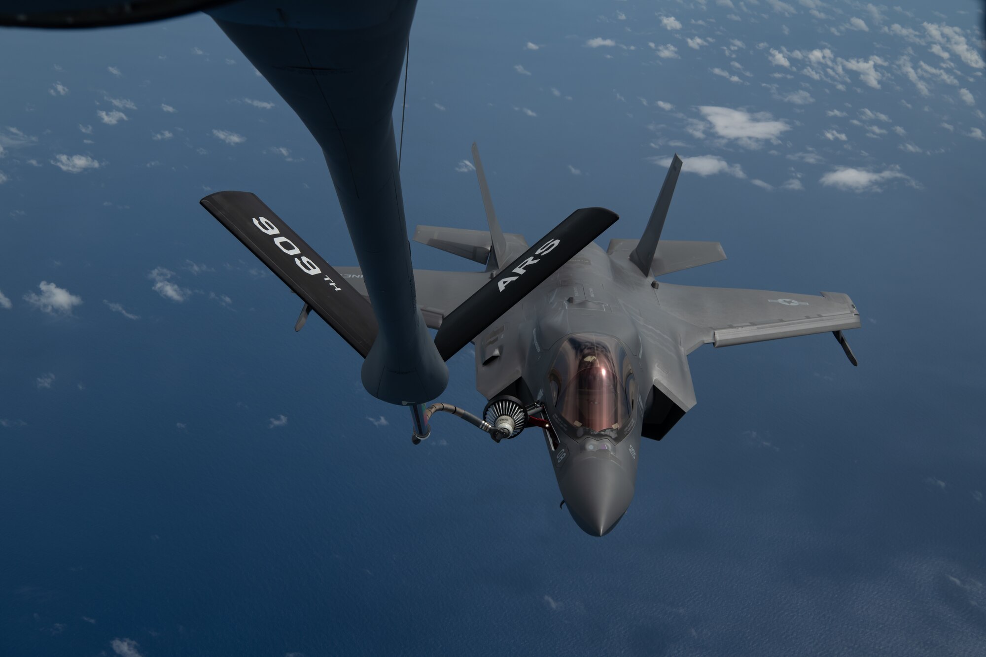 A U.S. Marine Corps F-35B Lightning II Marine Fighter Attack Squadron based out of Marine Corps Air Station MCAS Iwakuni, Japan receives fuel from a from a KC-135 Stratotanker assigned to the 909th Air Refueling Squadron, Kadena Air Base, Japan during a Large Scale Global Exercise 21 mission over the western Pacific Ocean, Aug. 18, 2021. The U.S. has the ability to operate from the sanctuary of bases across the region and projecting sustained combat power.  (U.S. Air Force photo by Tech. Sgt. Micaiah Anthony)