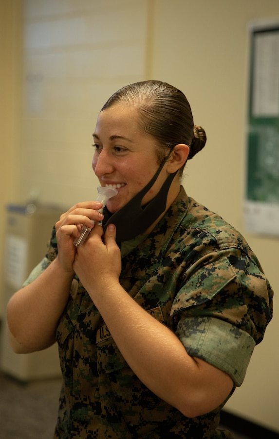 U.S. Marine Corps Sgt. Hailey Clay, a combat photographer with 3d Marine Logistics Group Communication Strategy and Operations, spits in a test tube during a COVID antibody research study conducted by U.S. Naval Medical Research Unit-2 on Camp Kinser, Okinawa, Japan, Aug. 9, 2021. The study was conducted amongst active duty Navy and Marine Corps personnel to investigate the percentage of Marines and Sailors previously infected with SARS-CoV-2, the virus that causes COVID-19. The purpose of the study is to understand how widespread COVID-19 infections are throughout the United States and Indo-Pacific Command. 3d MLG, based out of Okinawa, Japan, is a forward deployed combat unit that serves as III MEF’s comprehensive logistics and combat service support backbone for operations throughout the Indo-Pacific area of responsibility. (U.S. Marine Corps photo by Lance Cpl. Sebastian Aponte)