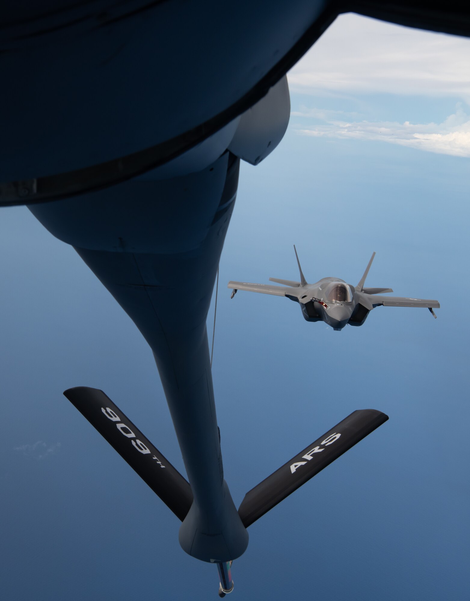 A U.S. Marine Corps F-35B Lightning II Marine Fighter Attack Squadron based out of Marine Corps Air Station (MCAS) Iwakuni, Japan flies into position to receive fuel from a KC-135 Stratotanker assigned to the 909th Air Refueling Squadron, Kadena Air Base, Japan during a Large Scale Global Exercise 21 mission over the western Pacific Ocean, Aug. 18, 2021. U.S. joint forces is the most lethal, capable, and innovative fighting force operating today. (U.S. Air Force photo by Tech. Sgt. Micaiah Anthony)