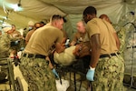 CAMP PENDLETON, Calif. (June 21, 2021) - Medical personnel assigned to Navy Expeditionary Medical Facility - M care for a simulated patient during a training exercise at Naval Expeditionary Medical Training Institute at Camp Pendleton, California.  The evolution evaluated the EMF’s patient processing and coordination across functional areas.  As a result, the EMF was certified with Tier 1 capability, with the ability to deploy and provide combat operations medical support to U.S. Fleet Forces.  (U.S. Navy photo by Hospital Corpsman 1st Class Nesinee Weber, Naval Expeditionary Medical Training Institute/ Released).