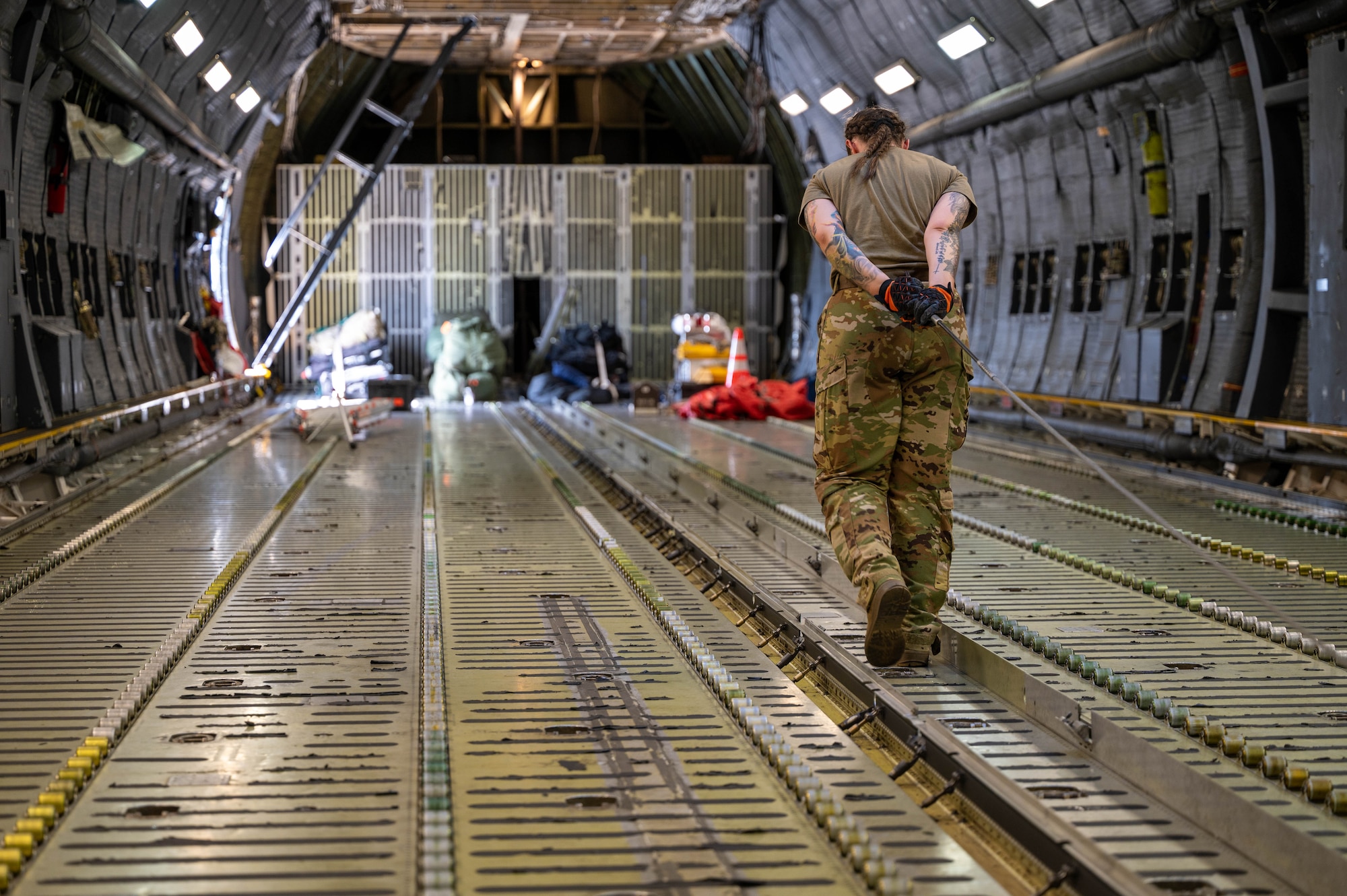 Senior Airman Anna Crocker, 9th Airlift Squadron loadmaster, performs a pre-flight wench check on a C-5M Super Galaxy before takeoff to Hamid Karzai International Airport, Afghanistan from Dover Air Force Base, Delaware, Aug. 16, 2021. Air Mobility Airmen play a key role in facilitating the safe departure and relocation of U.S. citizens, Special Immigration Visa recipients, and vulnerable Afghan populations from Afghanistan. (U.S. Air Force photo by Senior Airman Faith Schaefer)