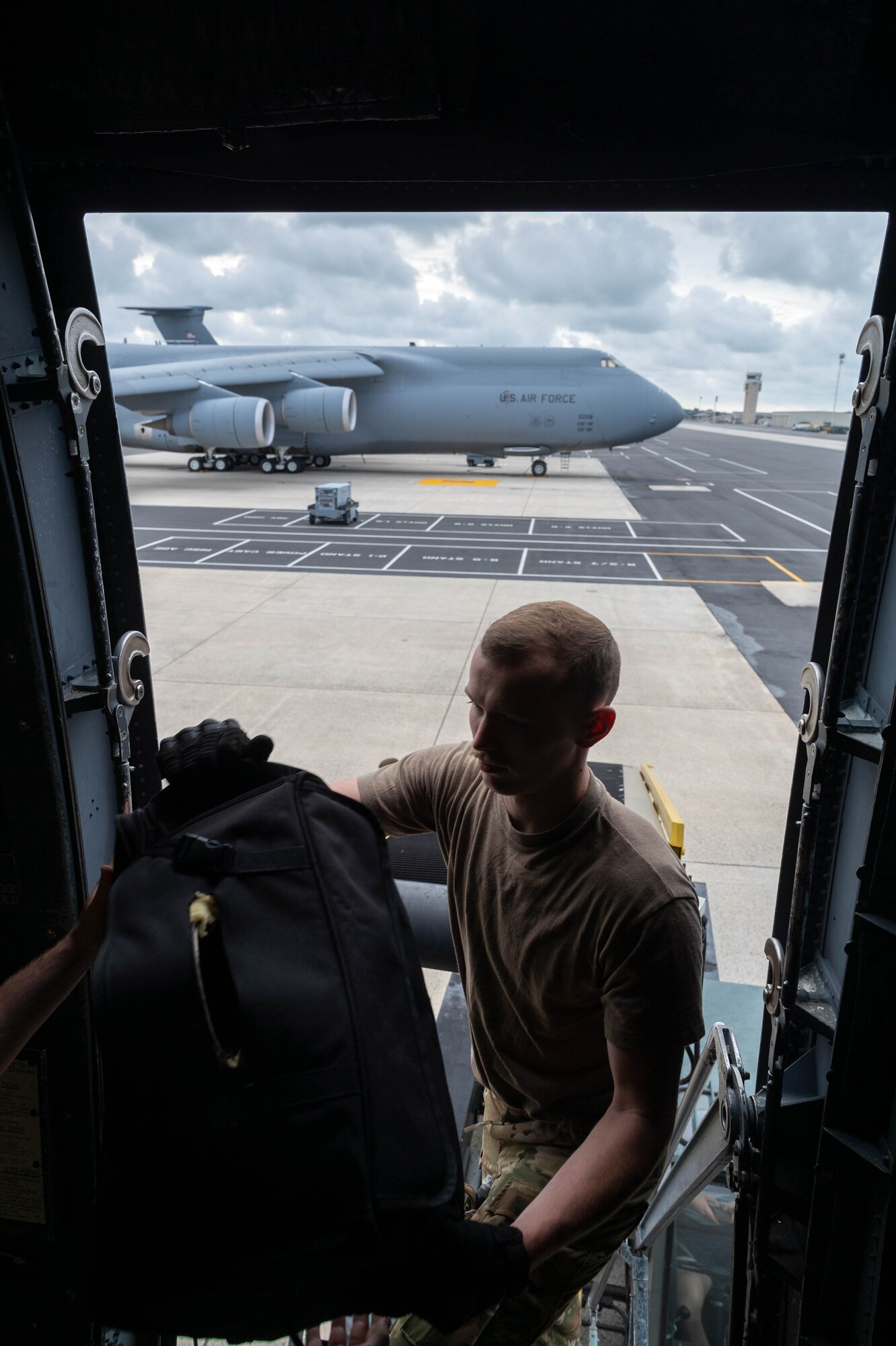 Staff Sgt. Hunter Barron, 9th Airlift Squadron loadmaster, loads luggage into a C-5M Super Galaxy before takeoff to Hamid Karzai International Airport, Afghanistan from Dover Air Force Base, Delaware, Aug. 16, 2021. Air Mobility Airmen play a key role in facilitating the safe departure and relocation of U.S. citizens, Special Immigration Visa recipients, and vulnerable Afghan populations from Afghanistan. (U.S. Air Force photo by Senior Airman Faith Schaefer)