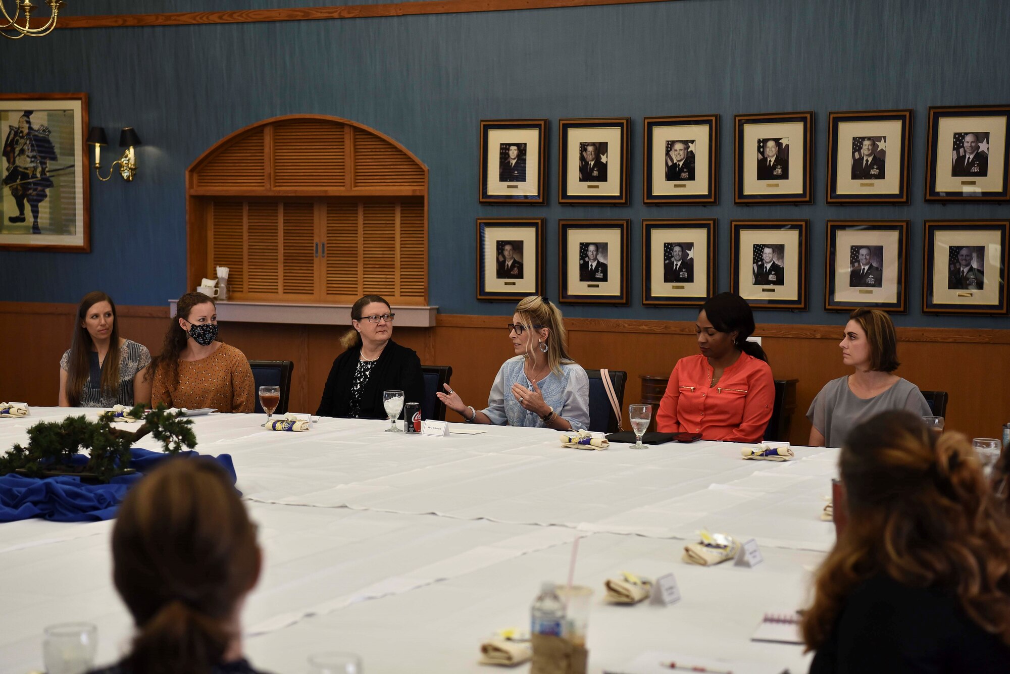 A group of ladies talk around a big table.