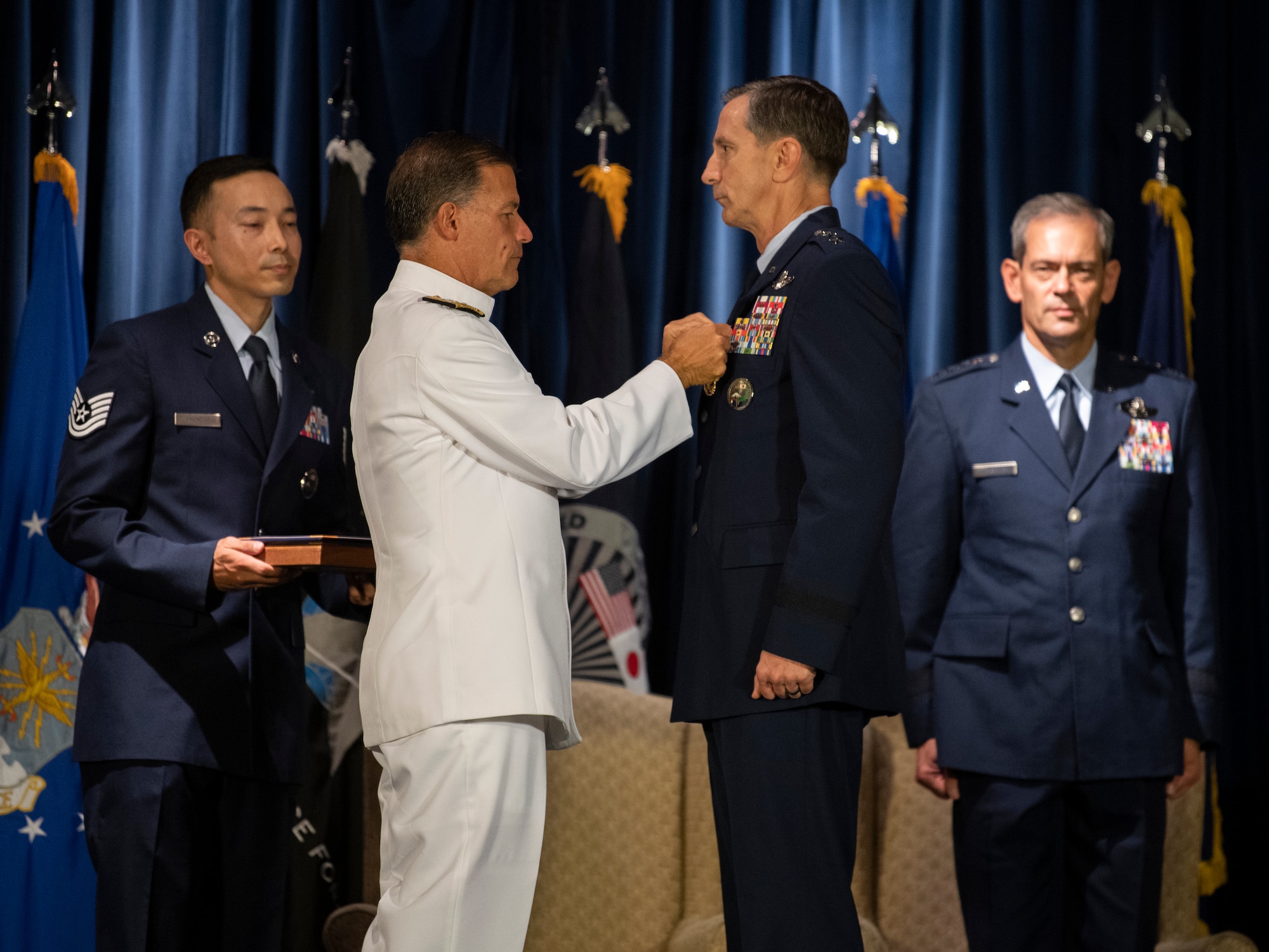 Admiral John C. Aquilino, U.S. Indo-Pacific Command commander, pins the Defense Distinguished Service medal to Lt. Gen. Kevin B. Schneider, U.S. Forces Japan and 5th Air Force outgoing commander, during the USFJ and 5th AF change of command ceremony at Yokota Air Base, Japan, Aug. 27, 2021.