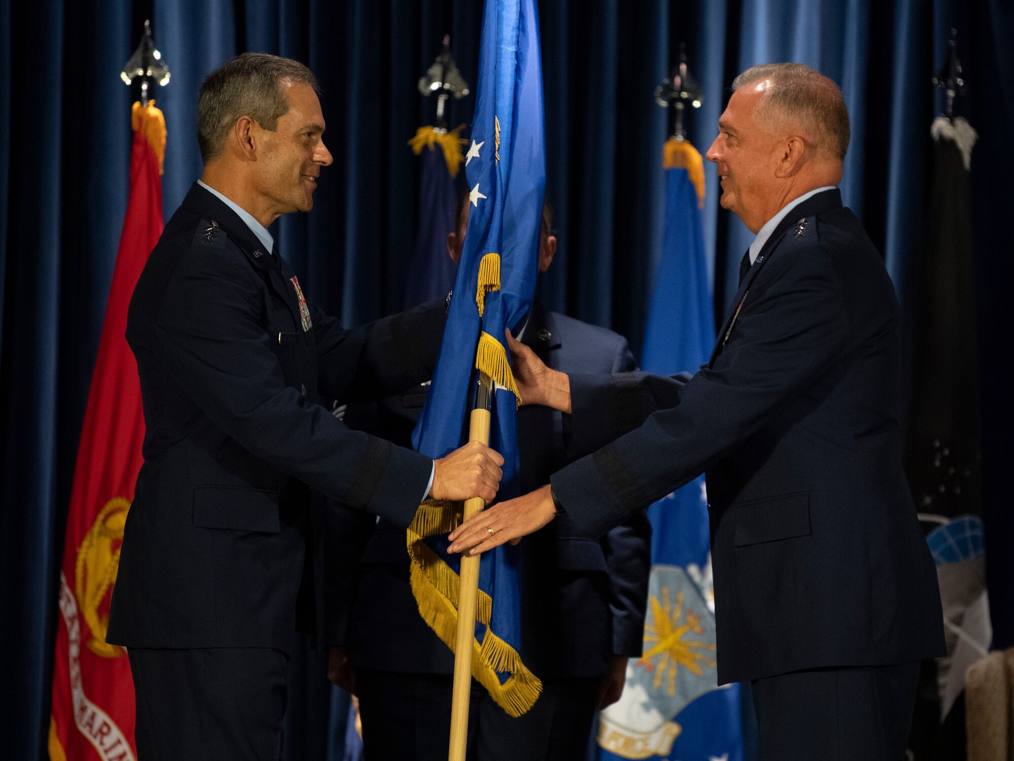 U.S. Air Force Gen. Ken S. Wilsbach, Pacific Air Forces commander, hands over the 5th Air Force command to Lt. Gen. Ricky N. Rupp, U.S. Forces Japan and 5th AF incoming commander, during the USFJ and 5th AF change of command ceremony at Yokota Air Base, Japan, Aug. 27, 2021. The passing of the guidon marks the beginning of Rupp’s tour as the commander of 5th AF. (U.S. Air Force photo by Senior Airman Brieana E. Bolfing)