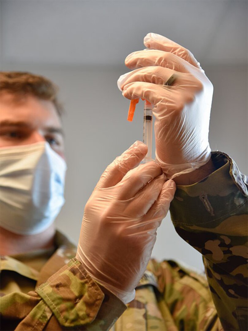 Spc. Anthony Spencer with the Tennessee National Guard prepares a COVID-19 vaccination dose for a patient at the Trousdale County Health Department June 9, 2021.