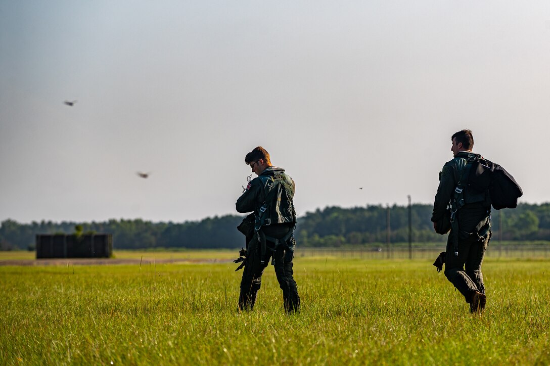 A photo of two pilots walking in a field.