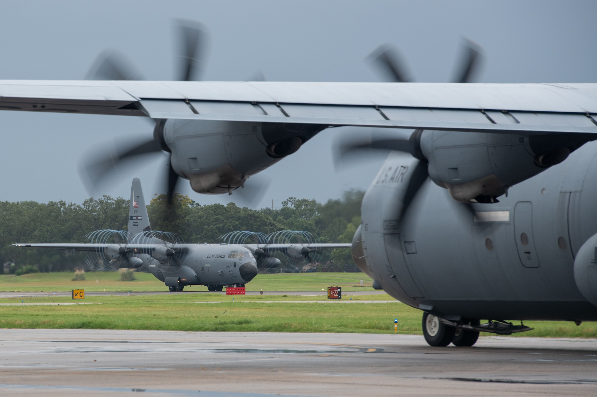 A WC-130J assigned to the 53rd Weather Reconnaissance Squadron at Keesler Air Force Base, Miss., takes off as a C-130J assigned to the 815th Airlift Squadron taxis to takeoff Aug. 27, 2021. Both squadrons evacuated to Kelly Field in San Antonio Texas ahead of anticipated Hurricane Ida. (U.S. Air Force by Staff Sgt. Kristen Pittman)