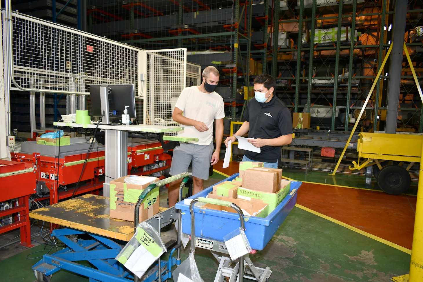 Jordan Lewis, left, and Jon Broughton, Fleet Readiness Center East production controllers, sort through parts to be stored in the Work-in-Process Inventory, Storage and Kitting (WISK) system.