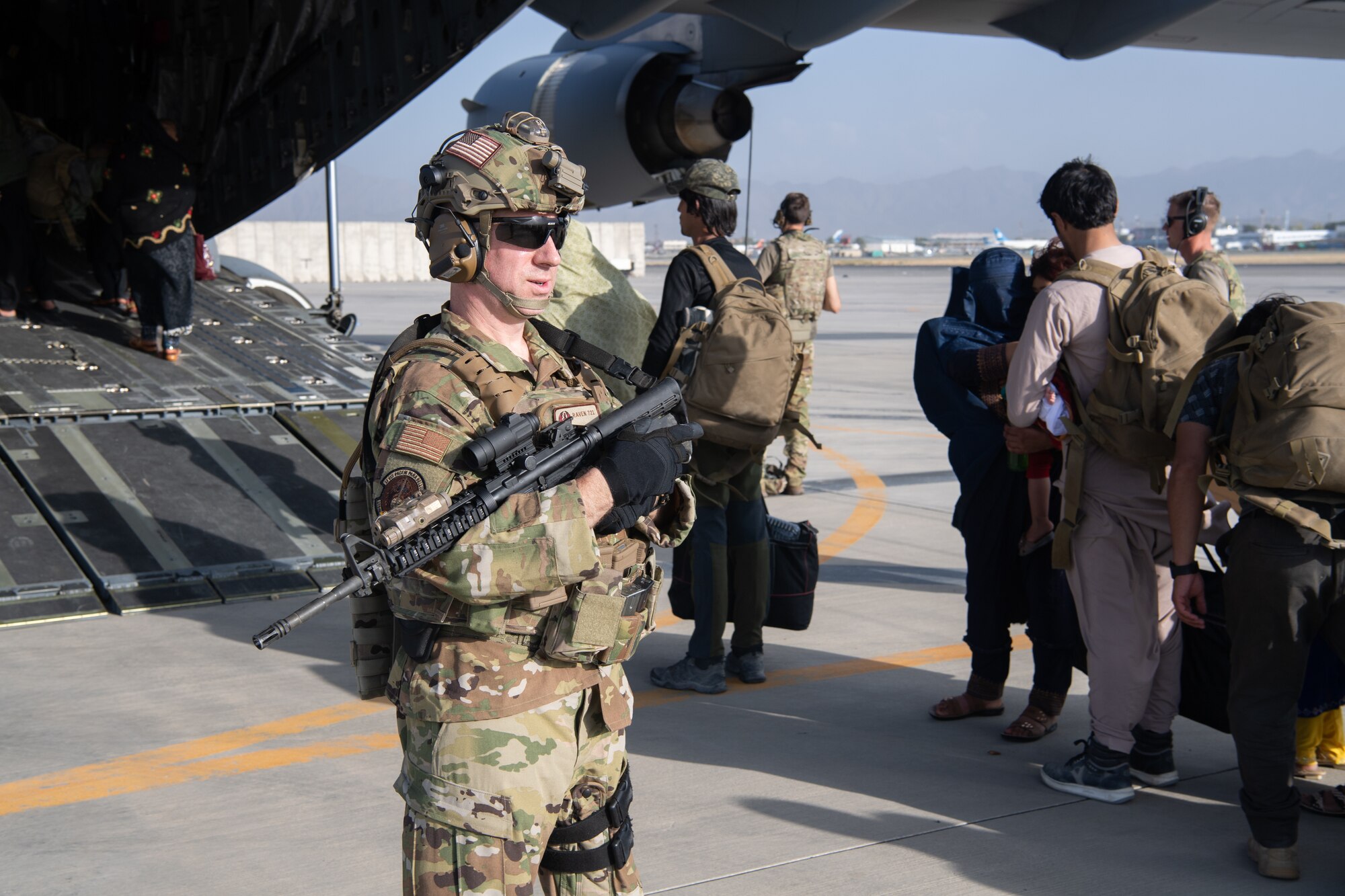 A U.S. Air Force security forces raven and Reserve Airmen assigned to the 816th Expeditionary Airlift Squadron, maintain a security cordon around a U.S. Air Force C-17 Globemaster III aircraft in support of the Afghanistan evacuation at Hamid Karzai International Airport (HKIA), Afghanistan, Aug. 24, 2021