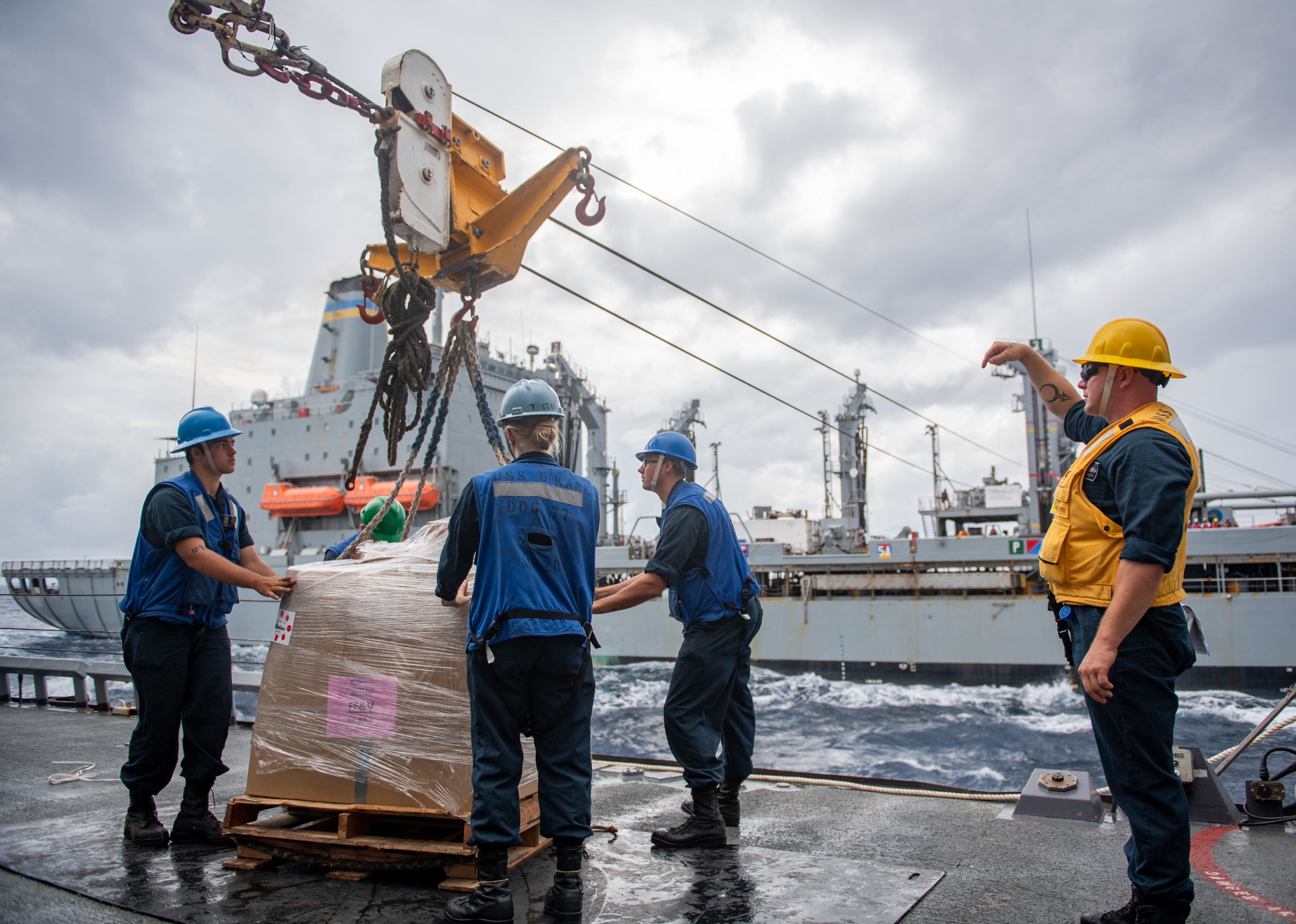 Sailors aboard USS O�Kane (DDG 77) receive cargo during a replenishment-at-sea with the Henry J. Kaiser-class underway replenishment oiler USNS Tippecanoe (T-AO 199).
