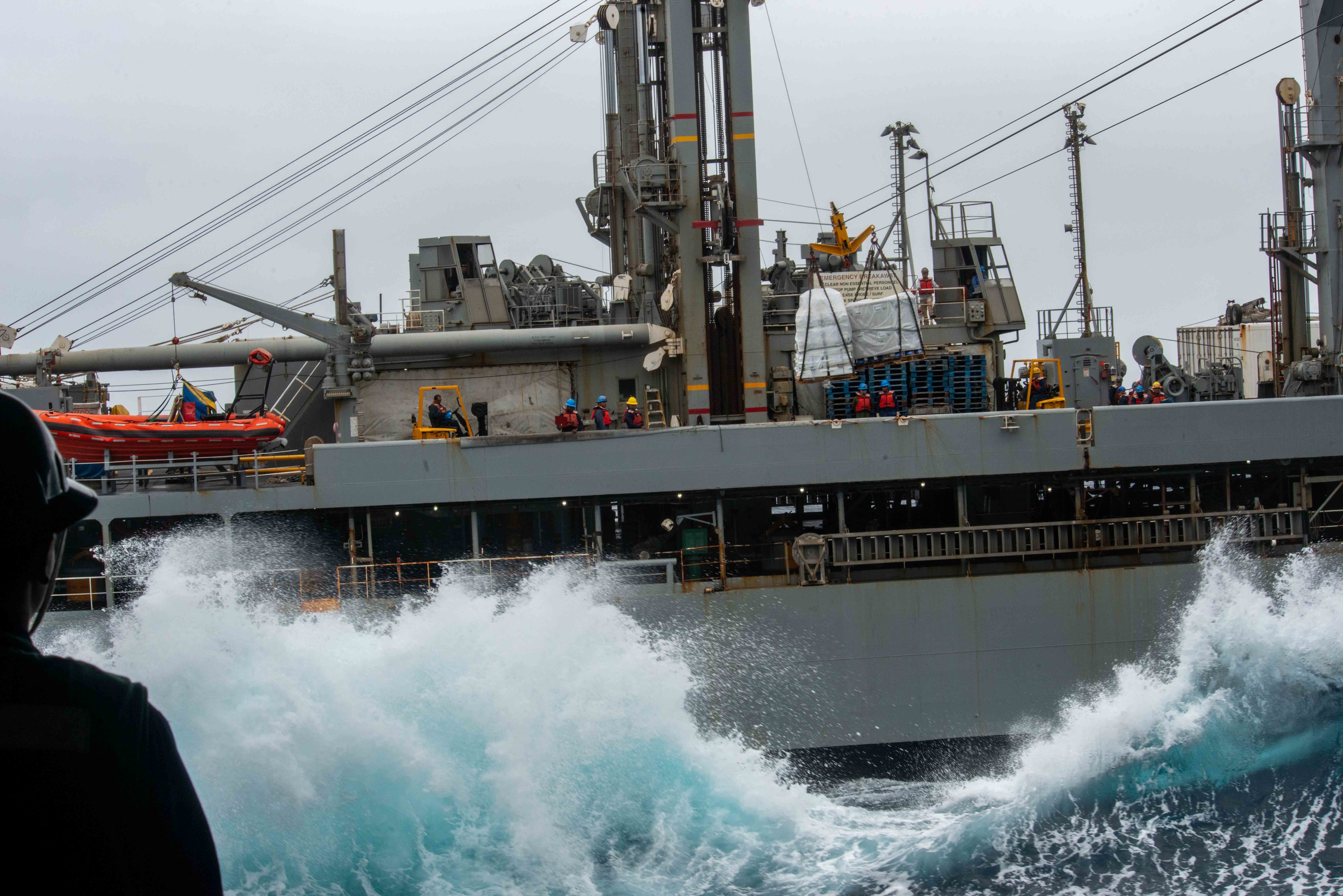 Waves crash against the Military Sealift Command fleet replenishment oiler USNS Pecos (T-AO 197) during a replenishment-at-sea with the aircraft carrier USS Ronald Reagan (CVN 76).