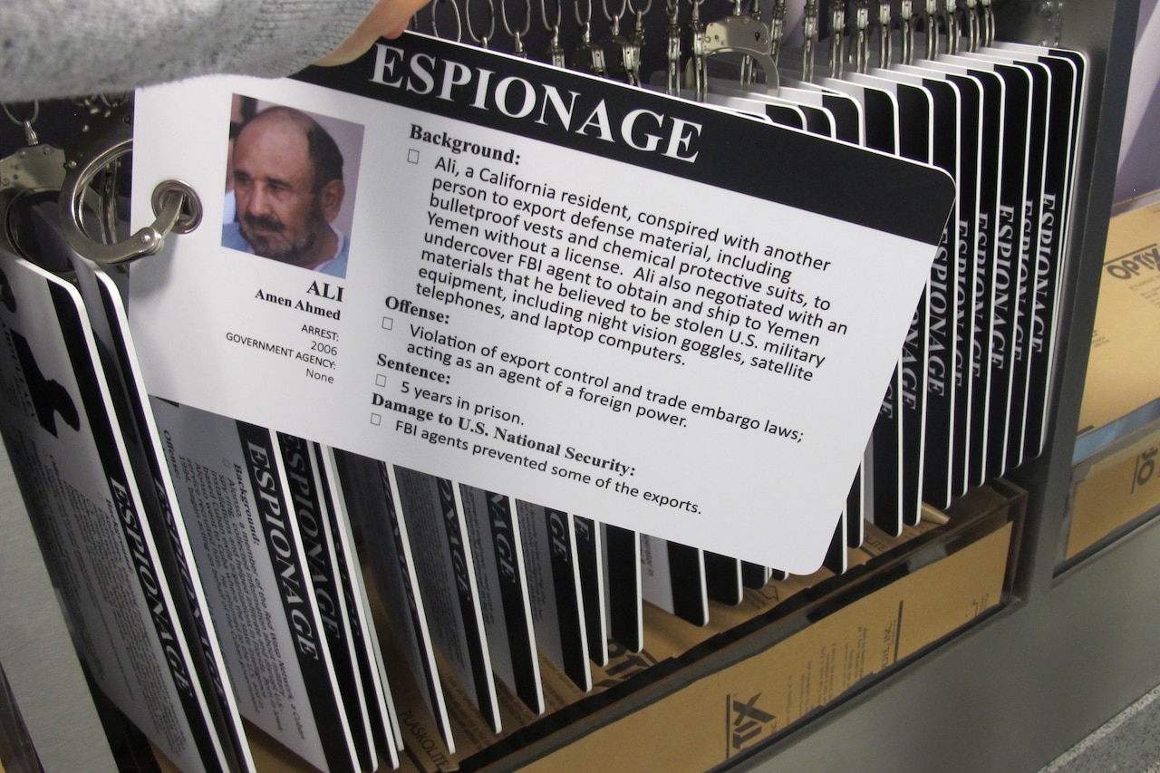 The image of a handcuffed card depicting a man and a paragraph listing his crimes is shown for an exhibit.