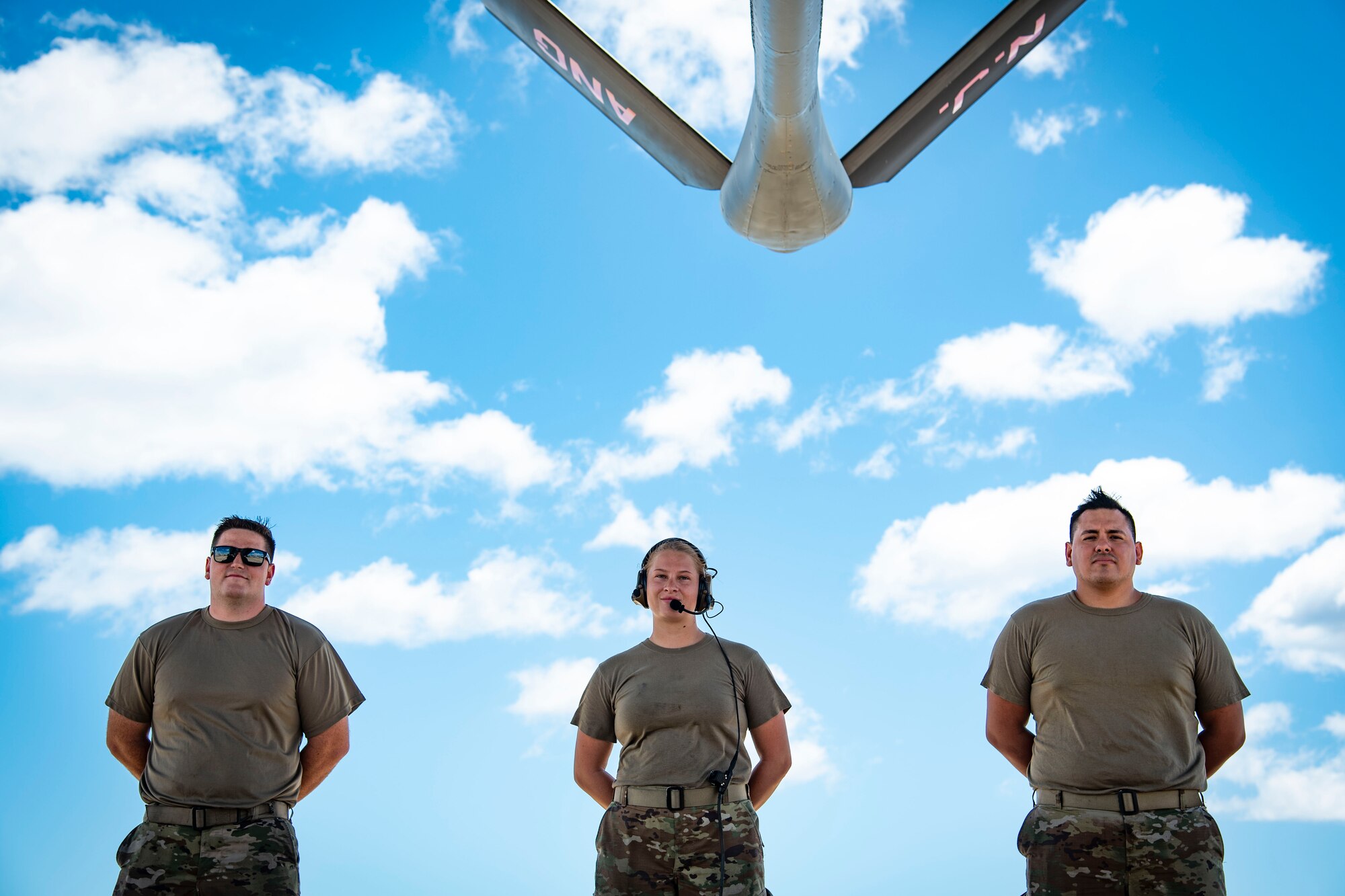 KC-135 maintainers pose outside near aircraft.