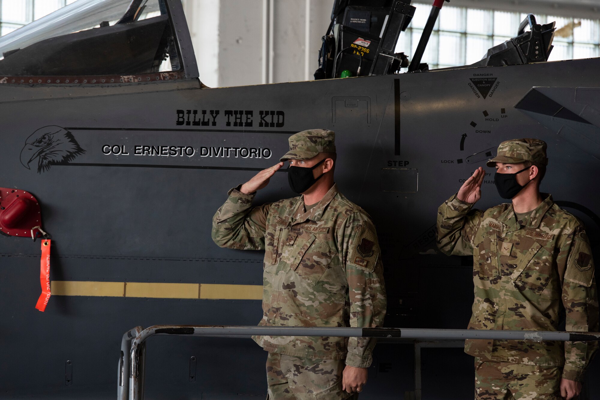 Two Airmen salute their new Wing commander.
