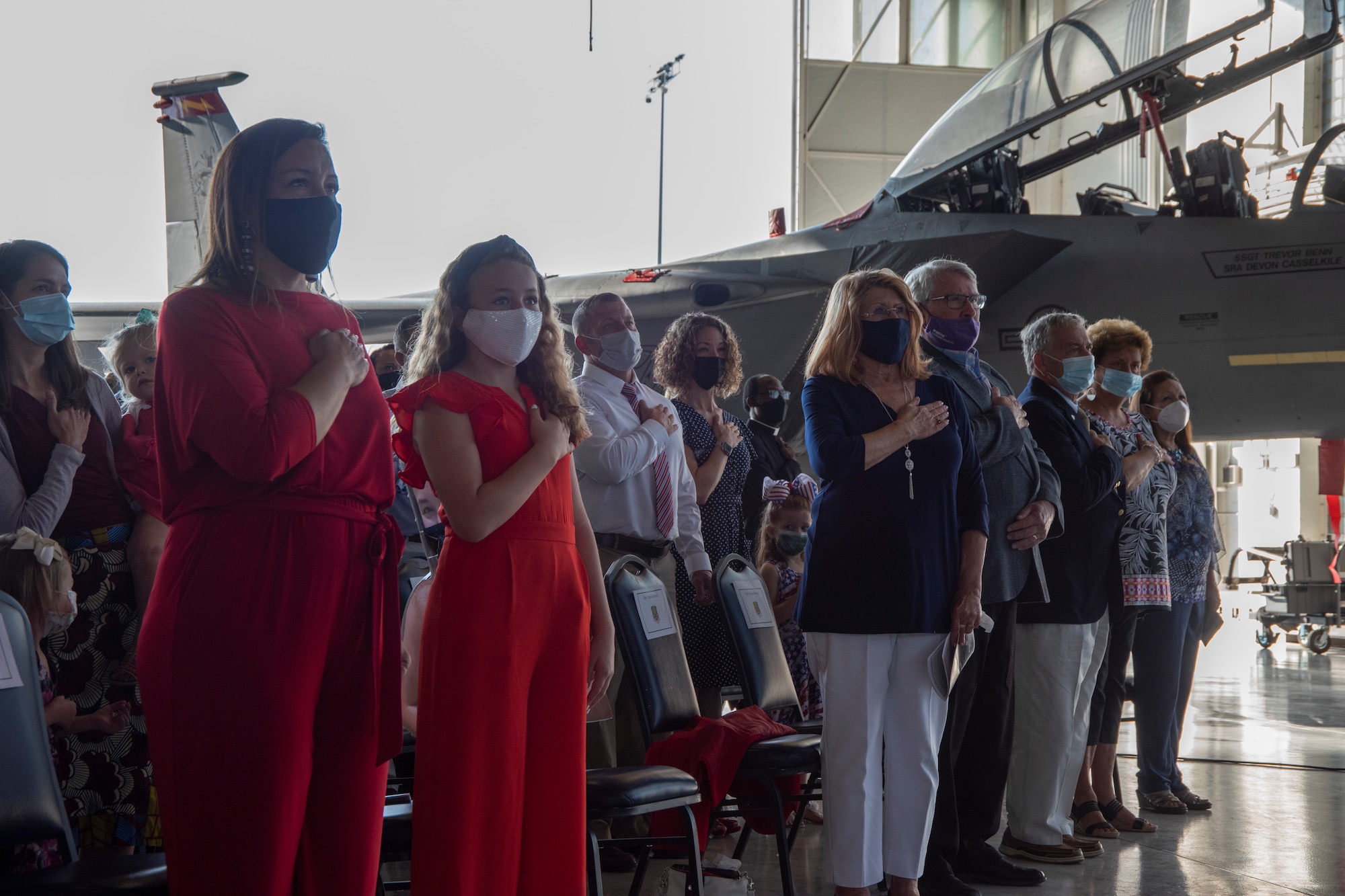 Col. Ernesto M. DiVittorio's family and the rest of the audience place their hand over their heart to the national anthem.