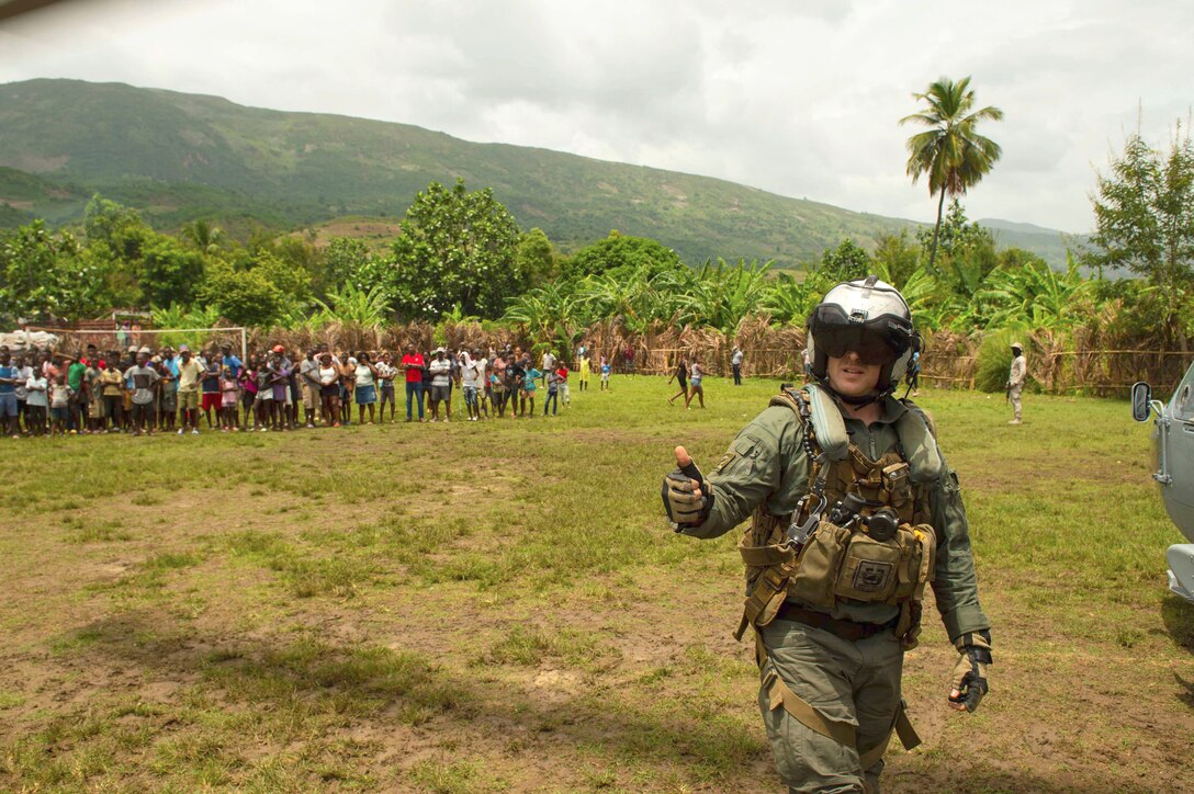 A Sailor gives a thumbs up moments after delivering the last box of food from an MH-60S Sea Hawk helicopter during a humanitarian aid mission supporting the U.S. Agency for International Development (USAID).