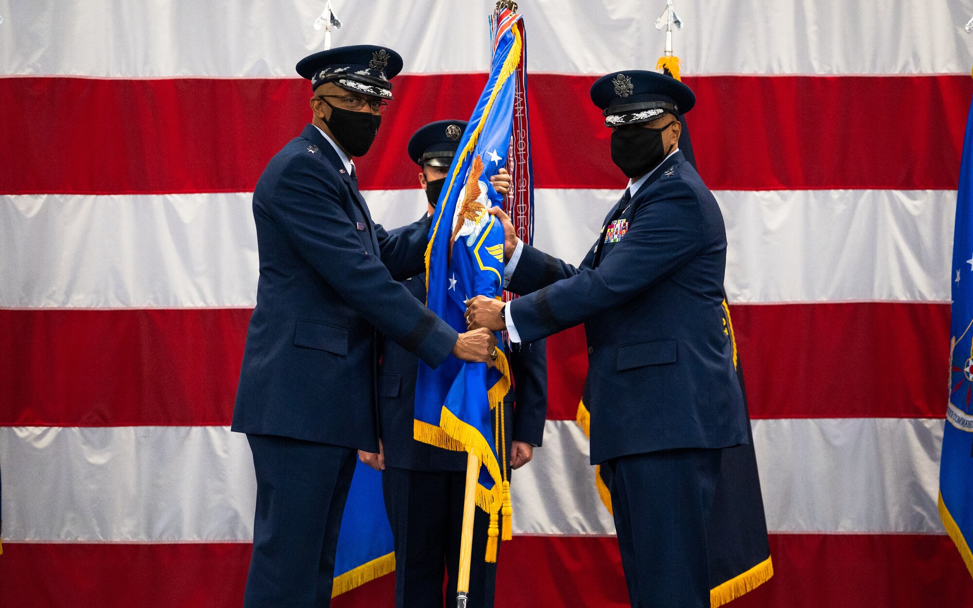 Gen. Anthony Cotton, right, incoming Air Force Global Strike Command commander, receives the guidon from Air Force Chief of Staff Gen. CQ Brown, Jr., left, during the AFGSC change of command ceremony at Barksdale Air Force Base, Louisiana, Aug. 27, 2021. The passing of a unit’s guidon symbolizes a transfer of command. (U.S. Air Force photo by Senior Airman Jacob B. Wrightsman)
