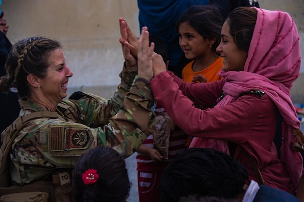 A Reserve Citizen Airmen with the Joint Task Force-Crisis Response high fives child after helping reunite their family at Hamid Karzai International Airport, Afghanistan, Aug. 20. U.S. service members are assisting the Department of State with a Non-combatant Evacuation Operation (NEO) in Afghanistan