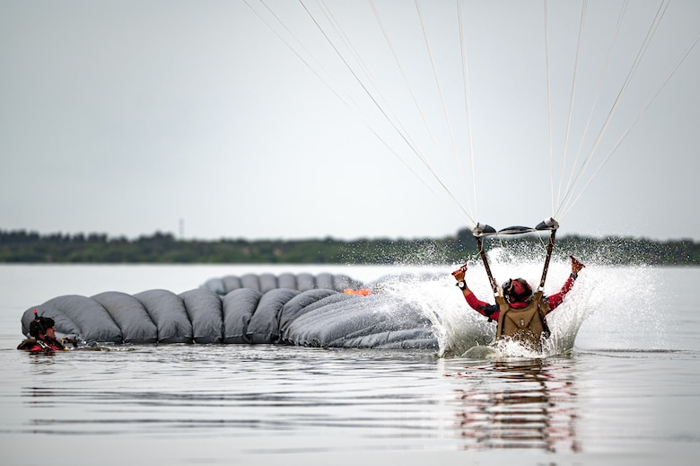 Photo of Airman landing in the water with a parachute