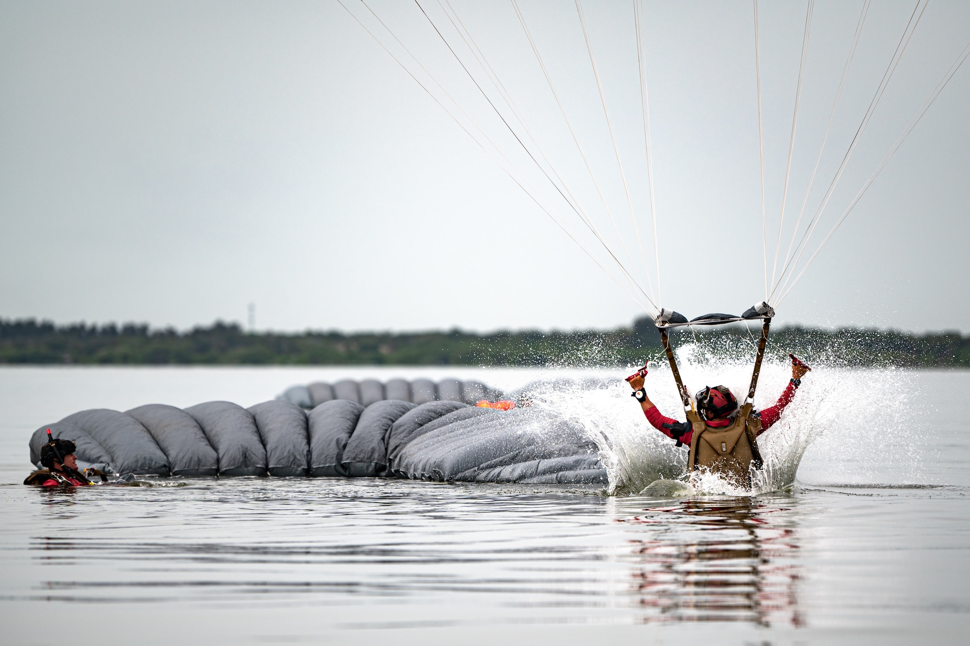 Photo of Airman landing in the water with a parachute