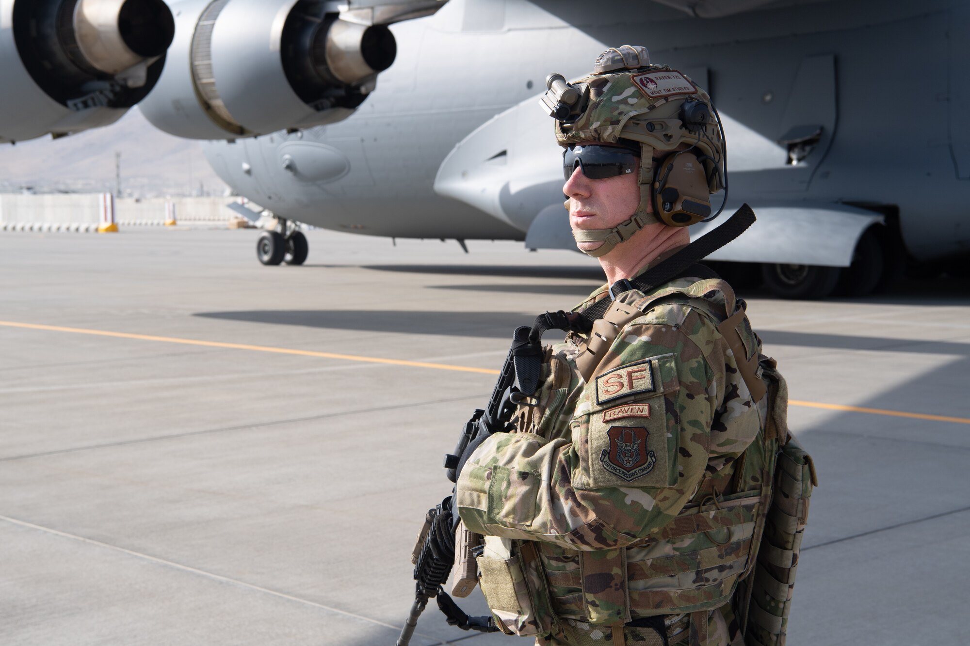 A U.S. Air Force security forces raven and Reserve Airmen assigned to the 816th Expeditionary Airlift Squadron, maintain a security cordon around a U.S. Air Force C-17 Globemaster III aircraft in support of the Afghanistan evacuation at Hamid Karzai International Airport (HKIA), Afghanistan, Aug. 24, 2021