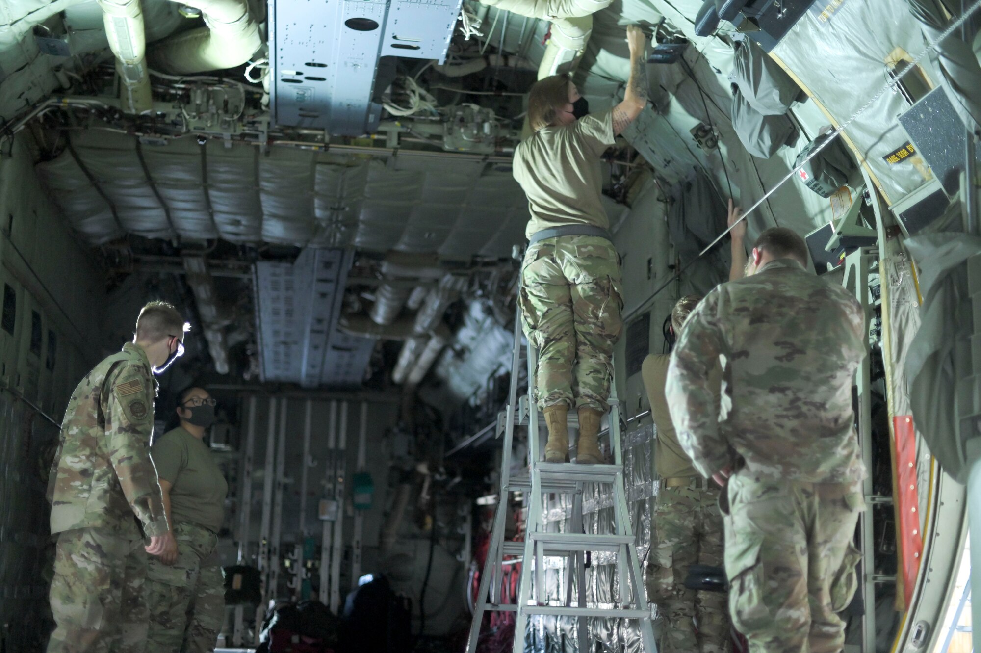 Airmen remove aircraft parts from a C-130