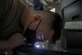 U.S. Air Force Senior Airman Dominick Ferneding, 18th Equipment Maintenance Squadron metals technology journeyman, closely inspects a 3-D printed object at Kadena Air Base, Japan, Aug. 25, 2021. The Metals Technology shop supports a variety of installations and units on base to help reduce costs for repairs or projects. (U.S. Air Force Photo by Senior Airman Demond Mcghee)